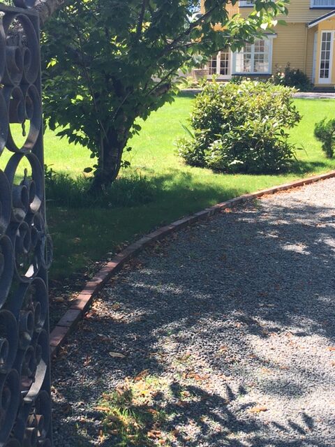 Recycled brick driveway lawn border after