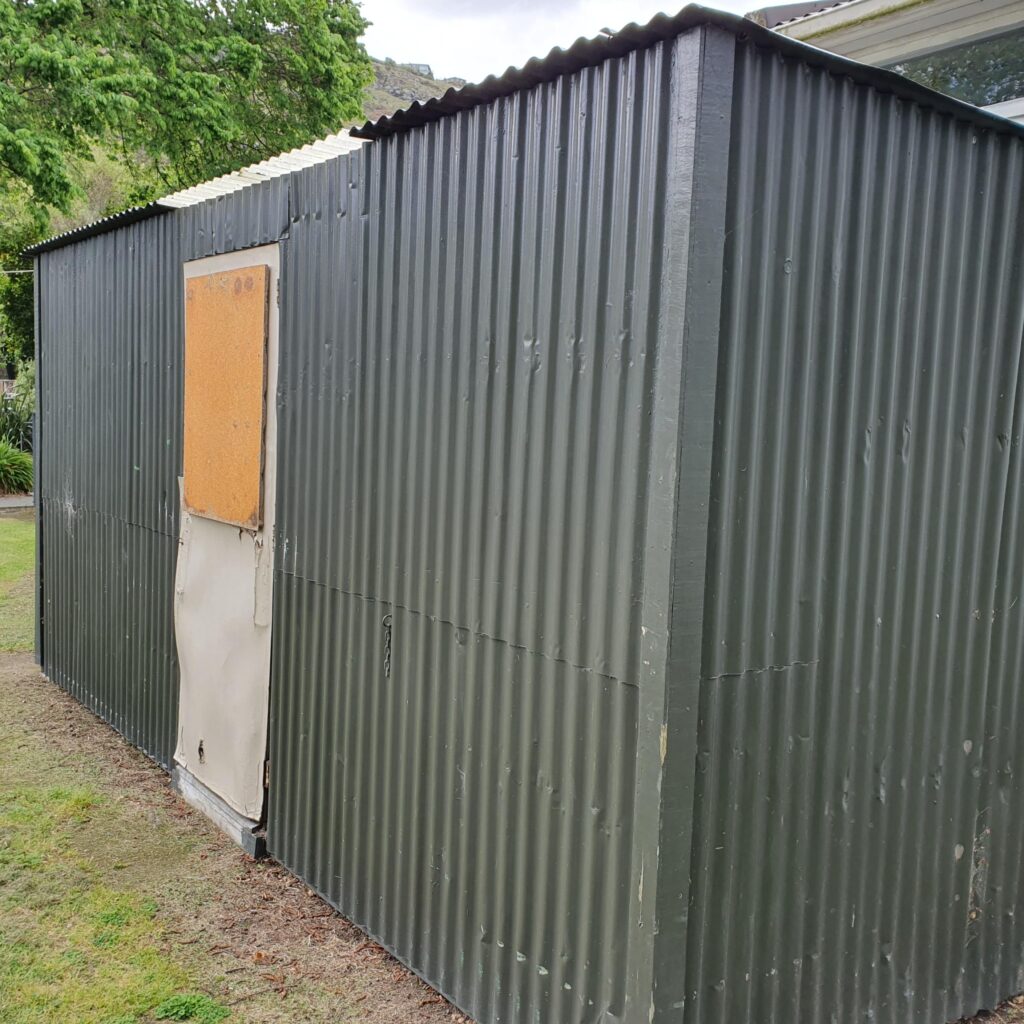 Recycled garden shed with dog on deck