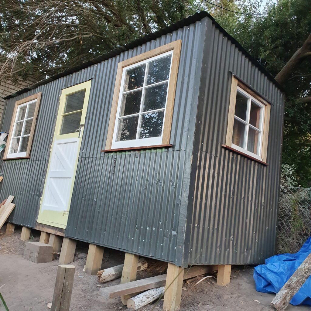 Recycled garden shed with dog on deck