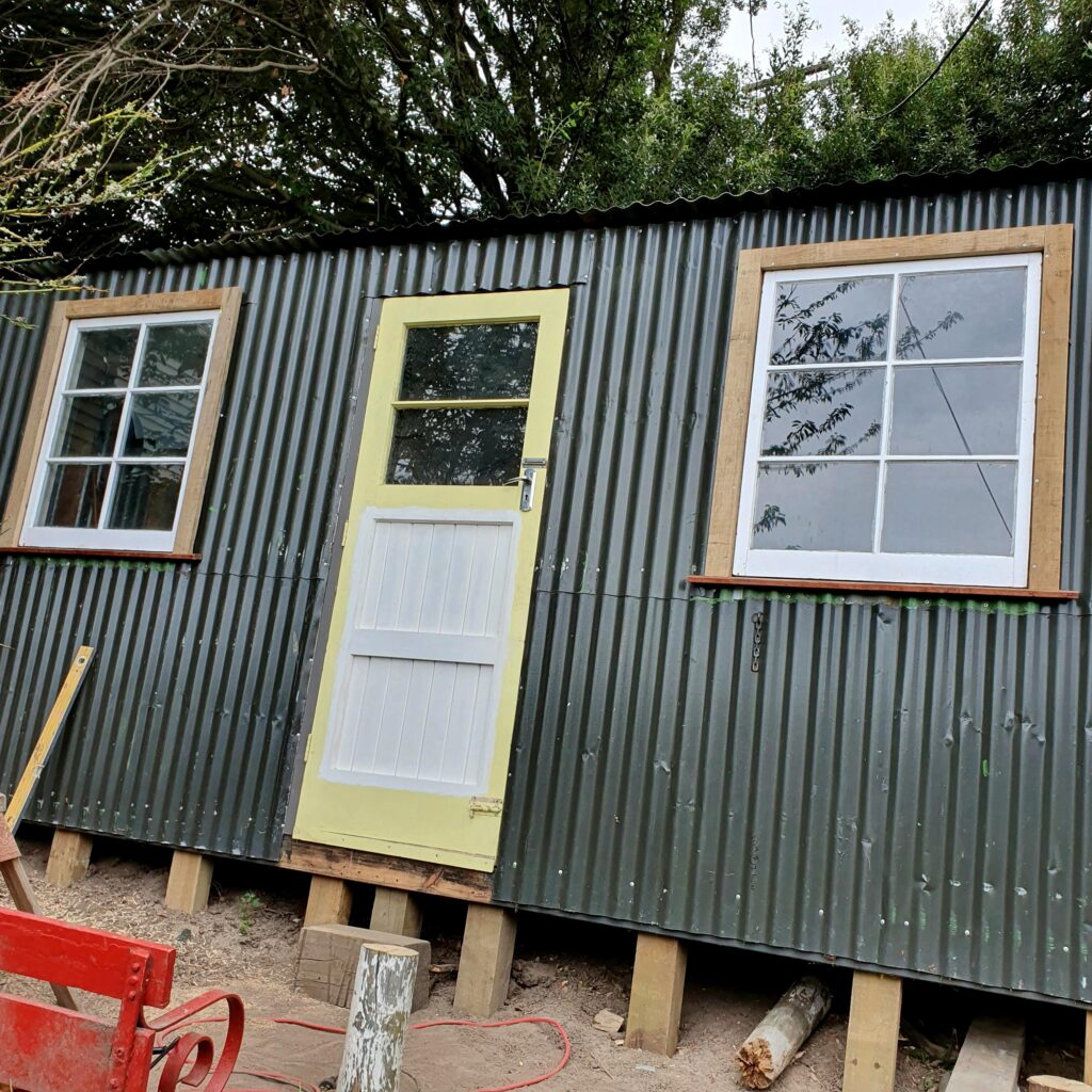 Recycled garden shed with dog on deck