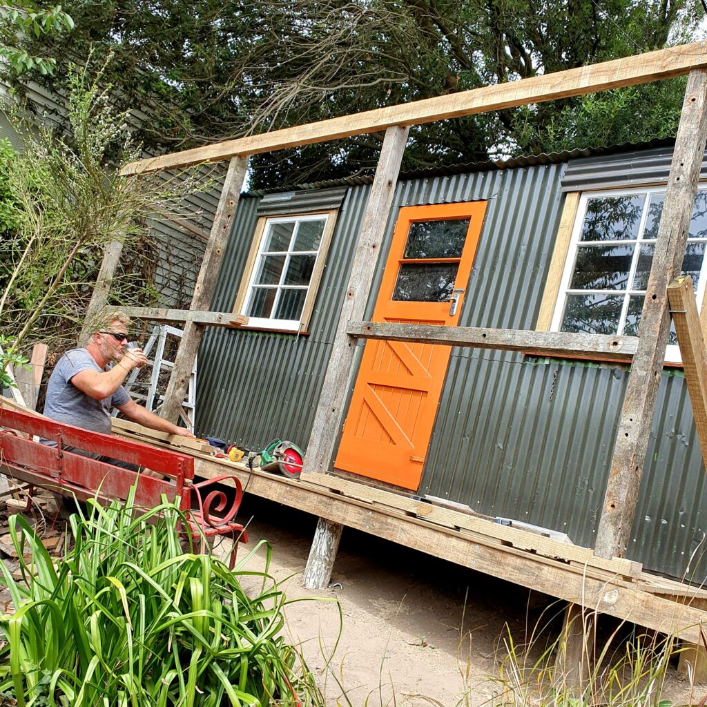 Recycled garden shed with dog on deck